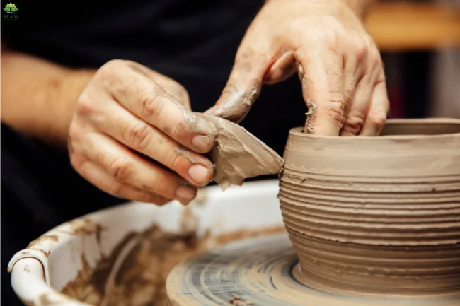 Artisan at work, molding wet clay into a beautiful vase, emphasizing the sustainable and natural origins of handmade ceramic pottery.