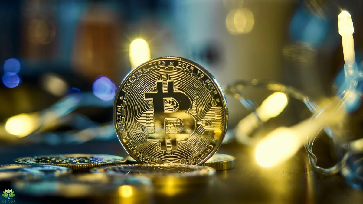 A close-up, high-quality photograph of a physical Bitcoin coin standing upright, surrounded by blurred bokeh lights. This image symbolizes the process of Bitcoin Mining and the value of digital assets.